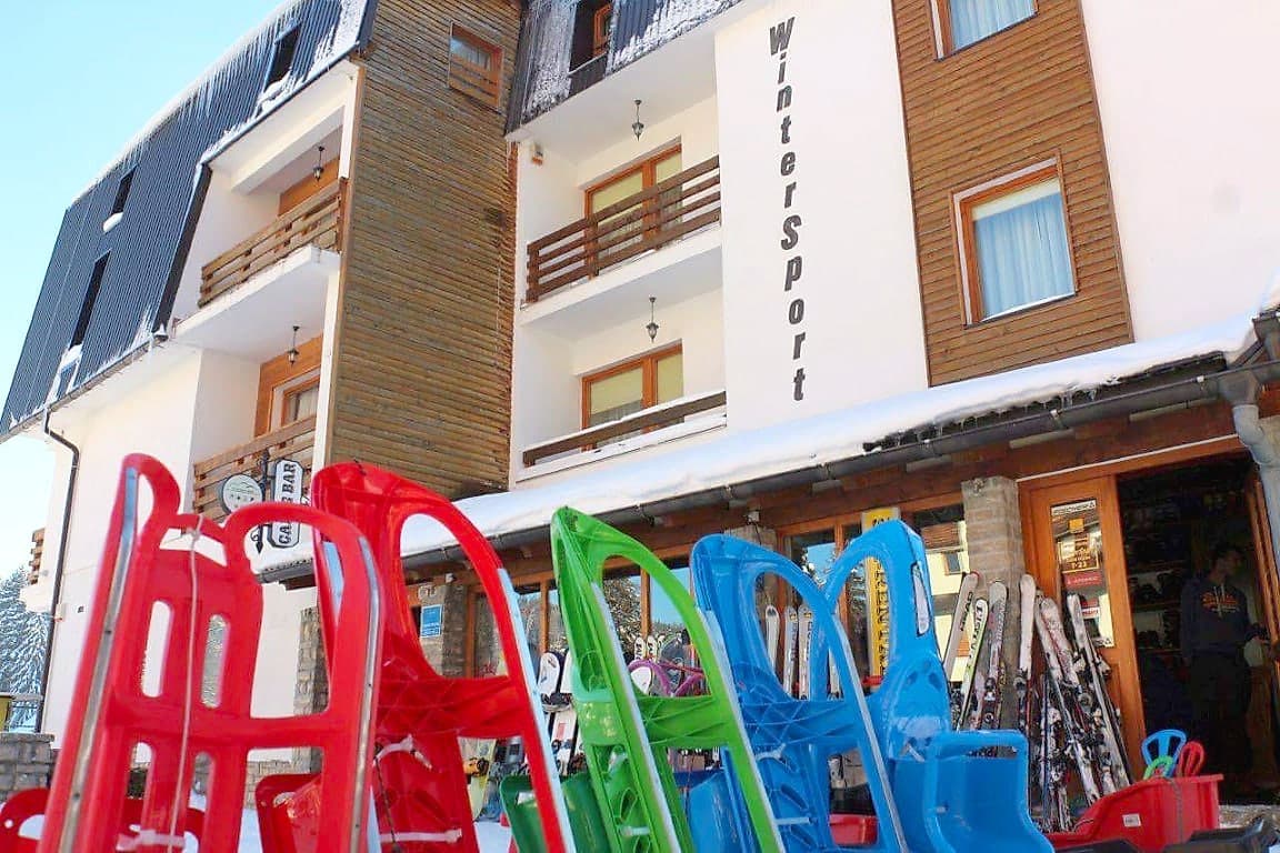 Fasada objekta WinterSport sa dječijim sankama i ski opremom ispred ulaza